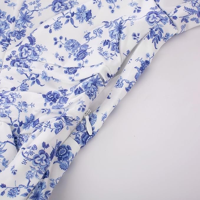 Robe vintage longue blanche à fleurs bleues avec manches bouffantes et col carré.