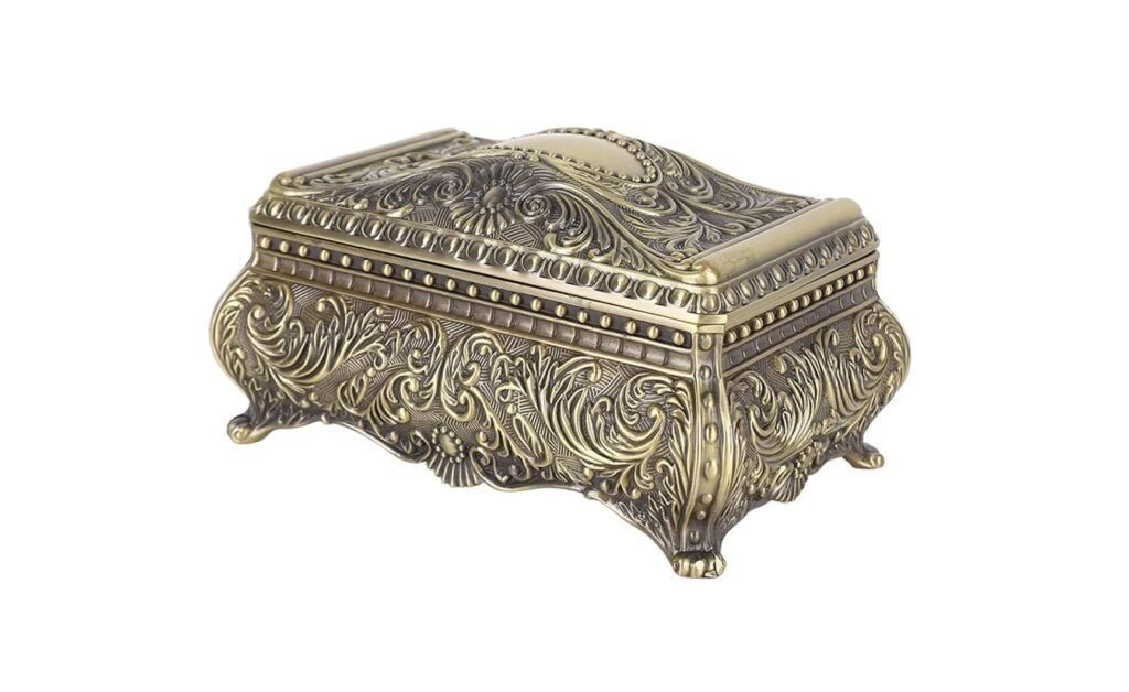 Boîte à bijoux vintage en métal doré avec motifs gravés et pieds décoratifs.