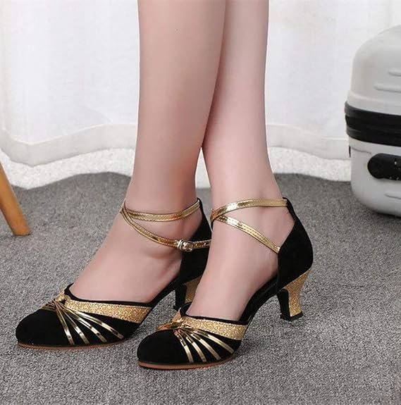 Chaussures de danse vintage noir et or à talon moyen et brides croisées.
