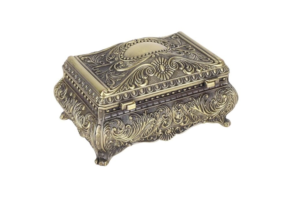 Boîte à bijoux vintage en métal doré avec motifs gravés et pieds décoratifs.