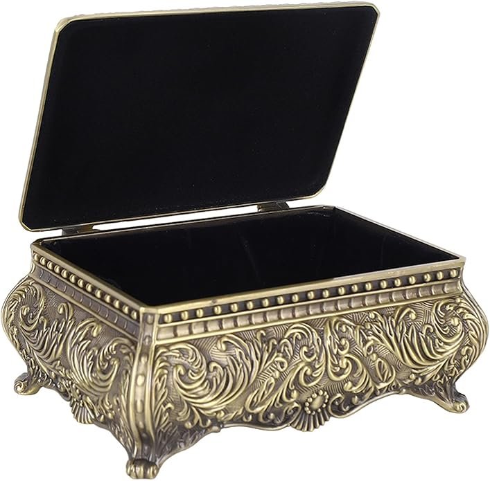 Boîte à bijoux vintage en métal doré avec motifs gravés et pieds décoratifs.