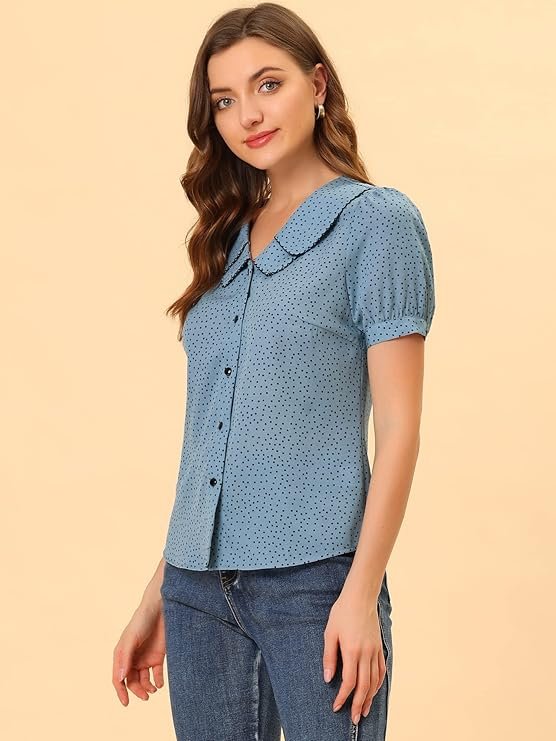Femme portant un chemisier bleu à pois noirs avec col Claudine et manches courtes.