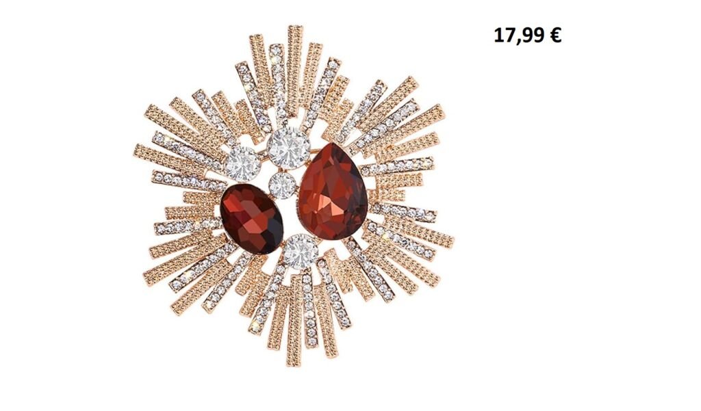 Broche vintage dorée en forme d’étoile avec strass et pierres rouges, présentée en écrin.